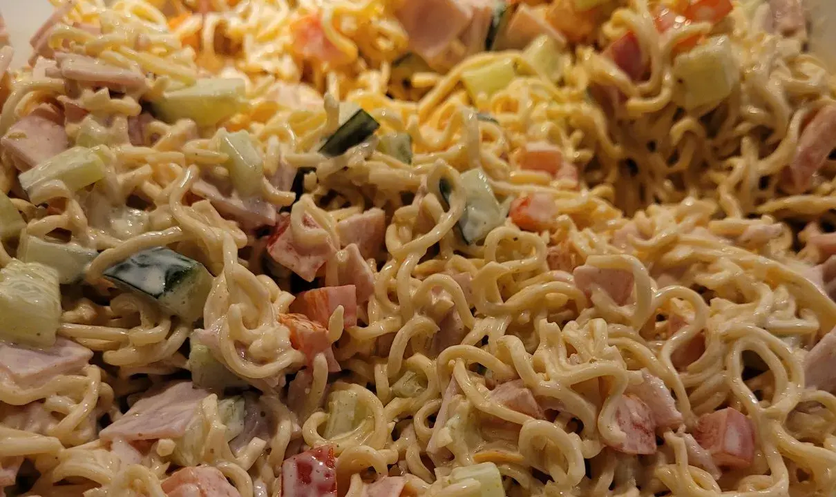 Pyszna sałatka z zupek chińskich z szynką, ogórkiem i pomidorem, polana kremowym sosem.