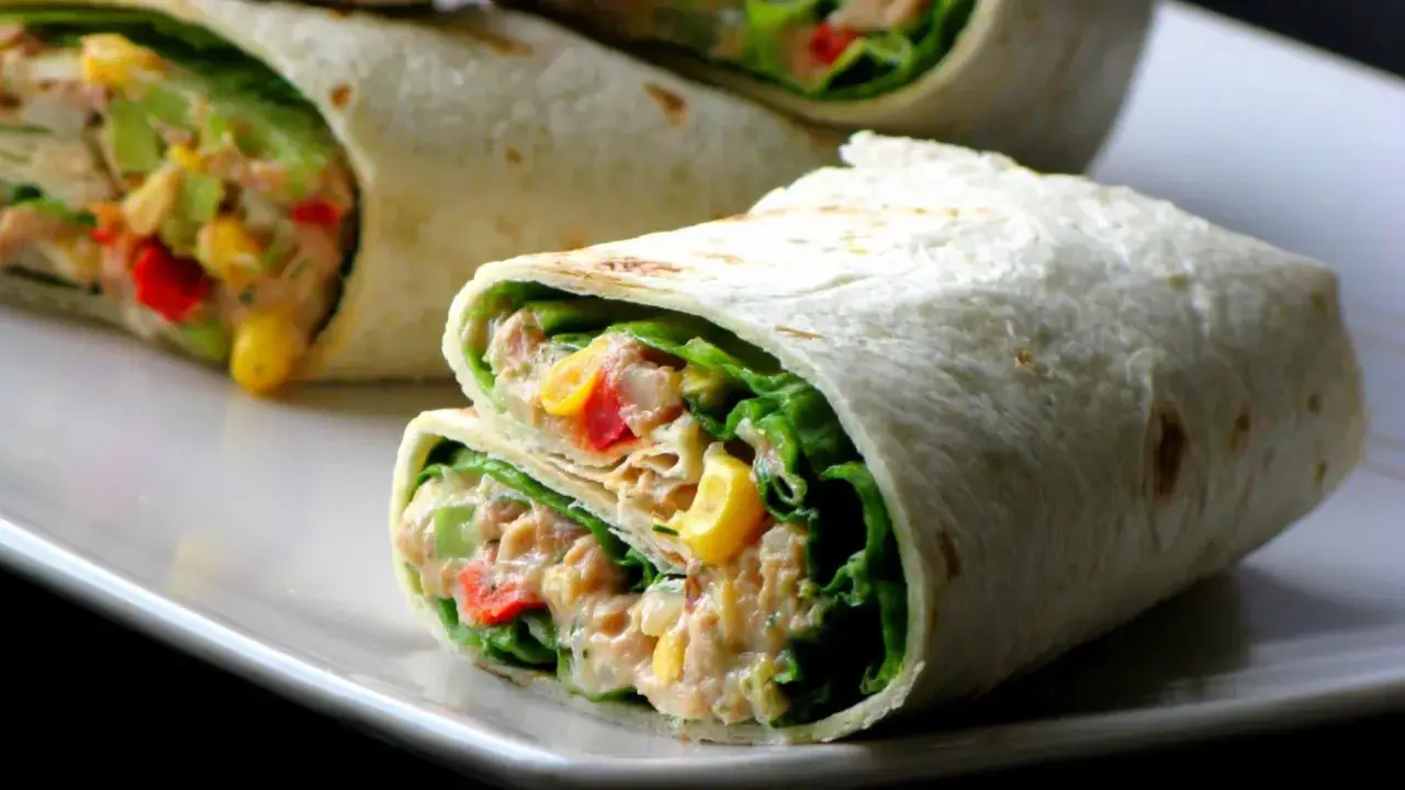 Pyszna tortilla z tuńczykiem, chrupiącą sałatą, kukurydzą i papryką. Idealna na szybki lunch.