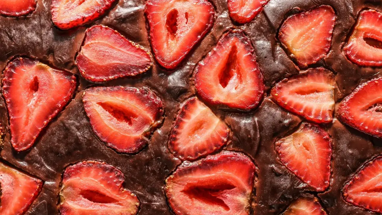 Pyszny brownie z truskawkami, z kawałkami owoców zatopionymi w czekoladowym cieście.