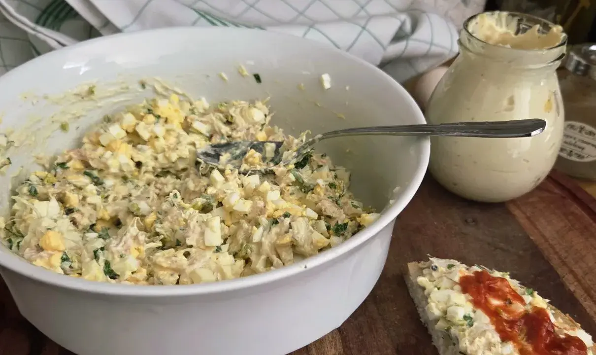 Pyszna pasta z wędzonego pstrąga z jajkiem i ziołami, gotowa do podania na kanapce.