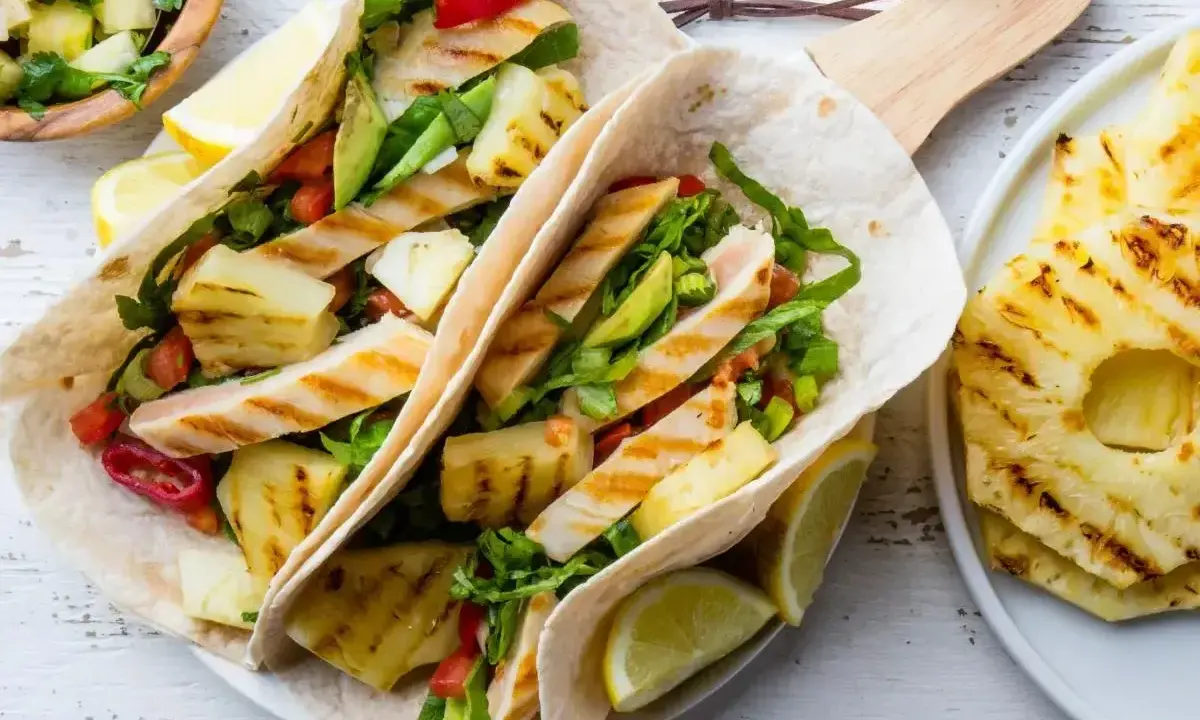 Tacos z grillowanym kurczakiem i ananasem – świetny pomysł na kolację na szybko. Świeże warzywa i cytrusy dodają smaku.
