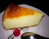 Pyszny sernik z jogurtu greckiego z lekko skarmelizowaną górą, podany na białym talerzu.