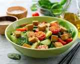 Pyszna sałatka z tofu, pomidorkami koktajlowymi i ogórkiem, posypana sezamem. Idealna na lekki posiłek.