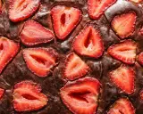 Pyszny brownie z truskawkami, z kawałkami owoców zatopionymi w czekoladowym cieście.