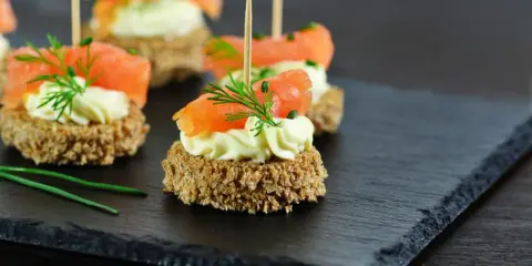 Eleganckie przystawki na urodziny: krakersy z łososiem, kremowym serkiem i koperkiem. Idealne na przyjęcie!