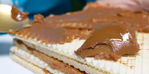 Warstwy wafli przekładane obficie kajmakiem, tworząc pyszny deser.