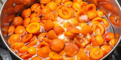 Gotowany dżem z moreli w dużym garnku, pełen soczystych, pomarańczowych owoców.