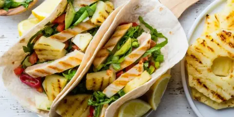 Tacos z grillowanym kurczakiem i ananasem – świetny pomysł na kolację na szybko. Świeże warzywa i cytrusy dodają smaku.
