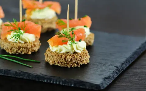 Eleganckie przystawki na urodziny: krakersy z łososiem, kremowym serkiem i koperkiem. Idealne na przyjęcie!