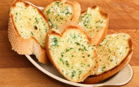Chrupiące grzanki z piekarnika, posypane czosnkiem i natką pietruszki, kuszą swoim aromatem.