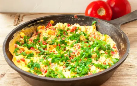 Pyszny omlet na słono z pomidorami i szczypiorkiem, prosto z patelni. Idealny na śniadanie.