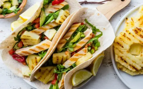 Tacos z grillowanym kurczakiem i ananasem – świetny pomysł na kolację na szybko. Świeże warzywa i cytrusy dodają smaku.