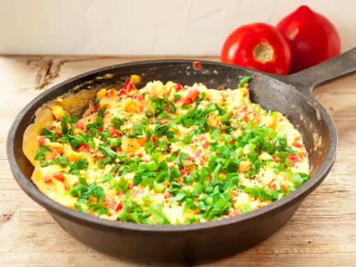 Pyszny omlet na słono z pomidorami i szczypiorkiem, prosto z patelni. Idealny na śniadanie.
