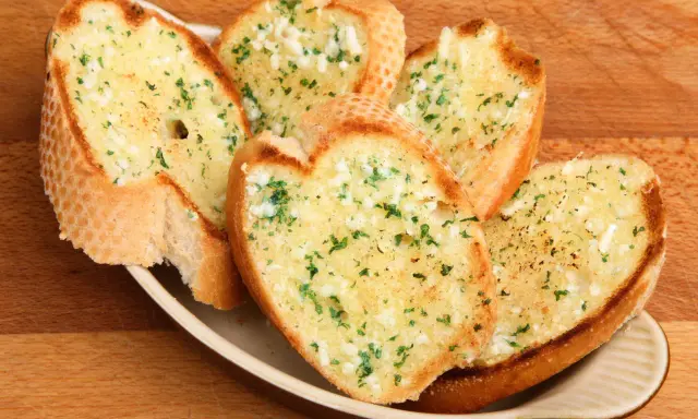 Chrupiące grzanki z piekarnika, posypane czosnkiem i natką pietruszki, kuszą swoim aromatem.