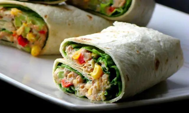 Pyszna tortilla z tuńczykiem, chrupiącą sałatą, kukurydzą i papryką. Idealna na szybki lunch.