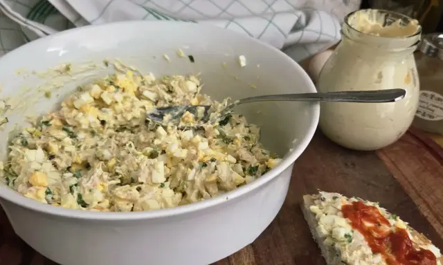 Pyszna pasta z wędzonego pstrąga z jajkiem i ziołami, gotowa do podania na kanapce.