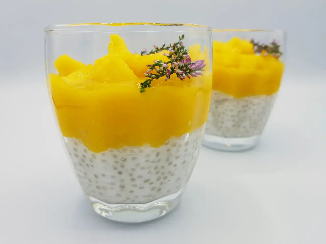 Pyszny deser z tapioki z mango, ozdobiony gałązką wrzosu.