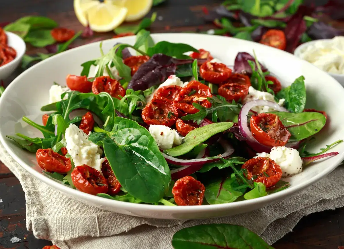 Kolorowa sałatka z rukolą, szpinakiem, serem feta, czerwoną cebulą i aromatyczną sałatką z suszonymi pomidorami.